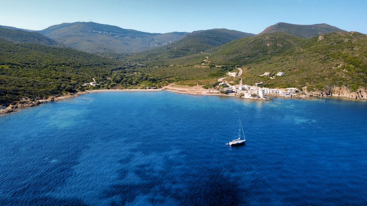 Vagabond au mouillage dans une crique, montagnes en arrière-plan